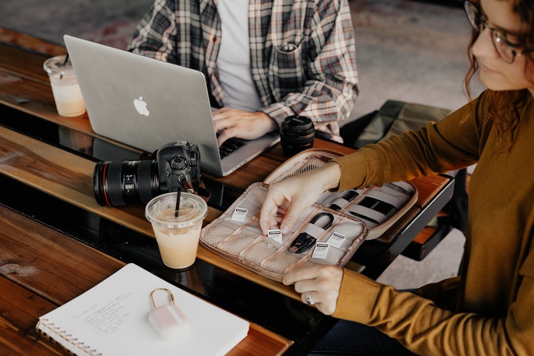 Diverse team of journalists collaborating around a table with laptops and documents