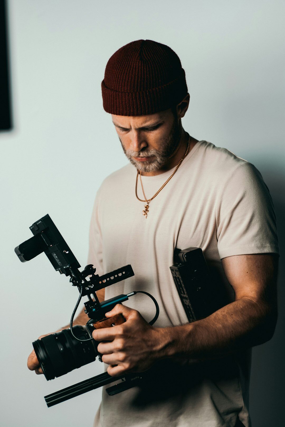 Studio portrait of a male field correspondent with camera equipment